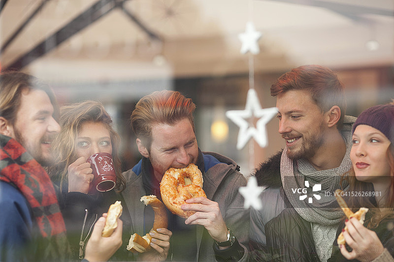 朋友们在冬季城市户外喝热饮图片素材