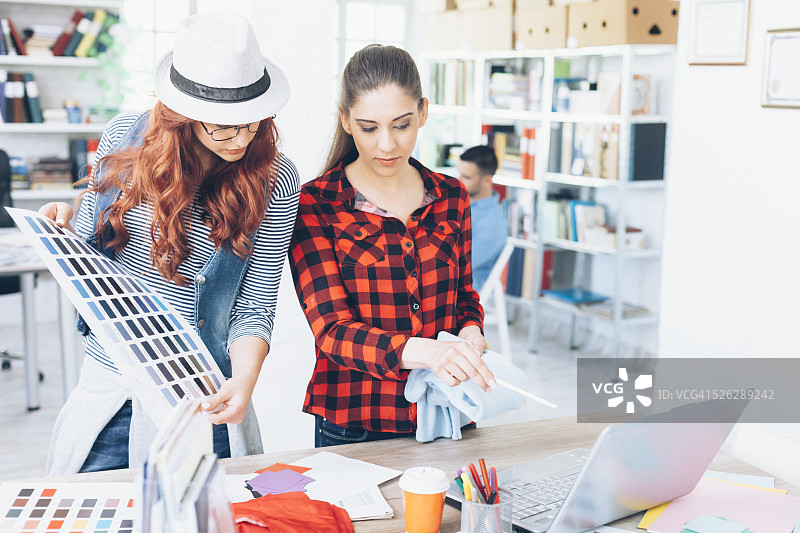 年轻女设计师拿着色卡工作图片素材