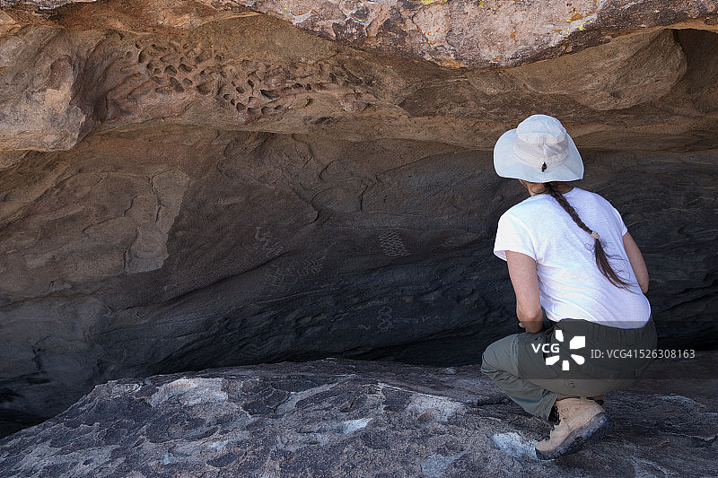 年轻女子欣赏德克萨斯州Hueco Tanks的岩画图片素材