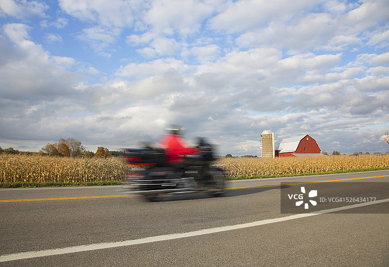 男人骑摩托车在农田中图片素材