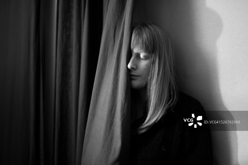 女人躲在窗帘后面图片素材