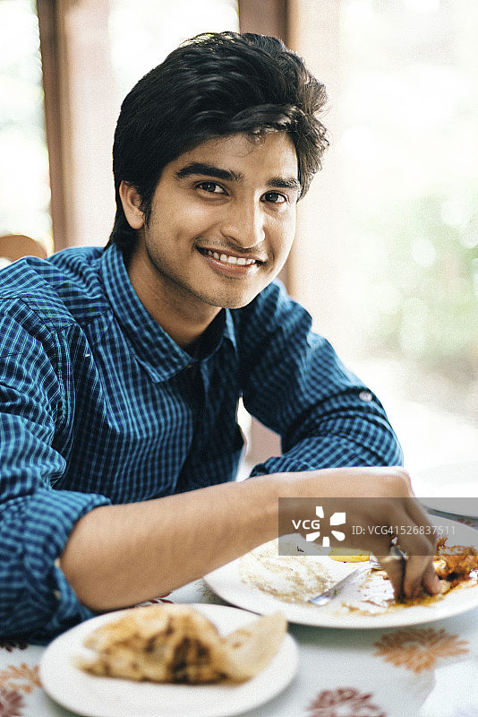 在印度餐厅用手吃饭的印度男人图片素材