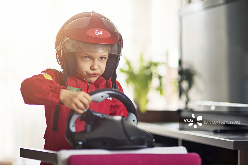 客厅赛跑 - 假装骑赛车的小男孩图片素材