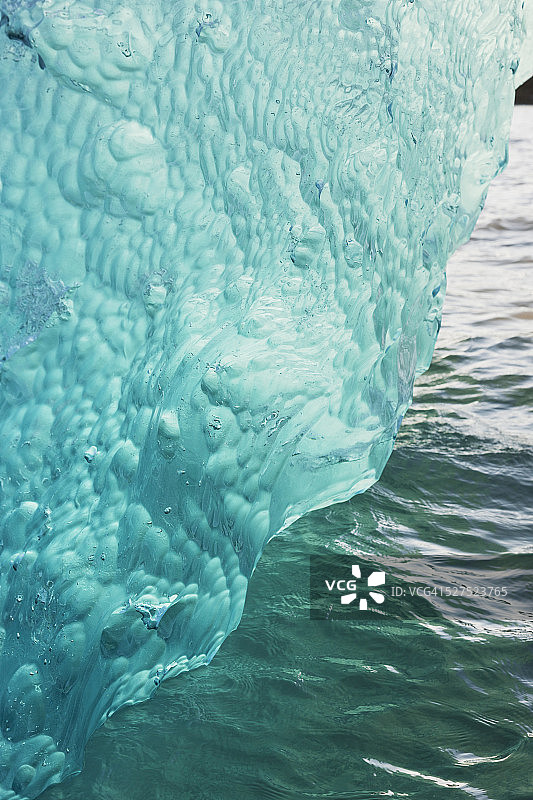 门登霍尔冰川断裂的冰山漂浮在门登霍尔湖中，翻转并露出水下蓝色抛光冰图片素材
