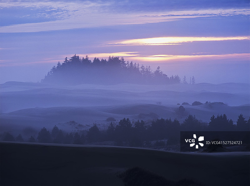 日落时分，太阳缓缓落下，笼罩着雾气图片素材