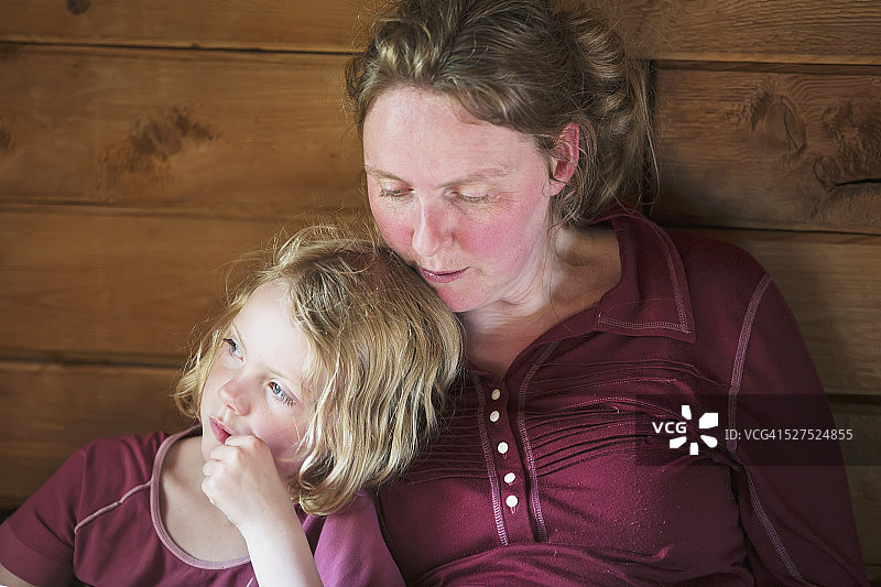 母女靠在木屋墙边一起读书图片素材