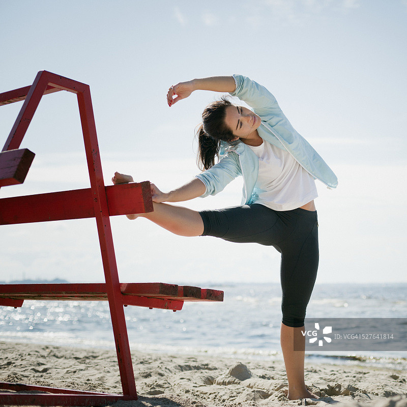 女人在沙滩上做拉伸运动图片素材