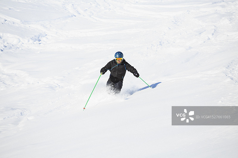 男人们在阳光明媚的滑雪胜地进行野雪粉雪滑雪图片素材