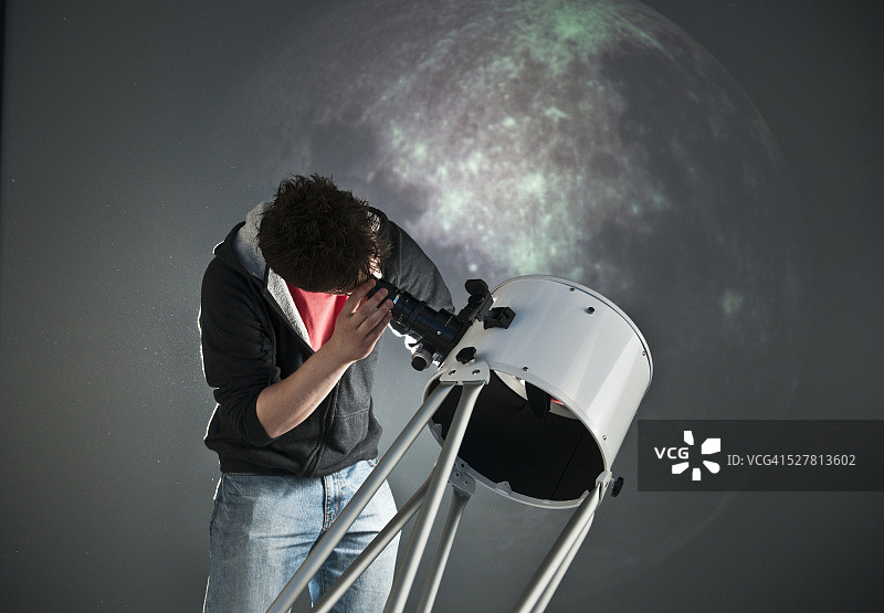 学生天文学家正在用望远镜观察图片素材