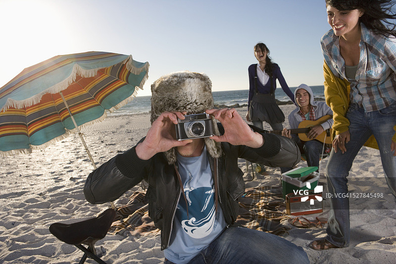 年轻男人在海滩派对上拍照图片素材