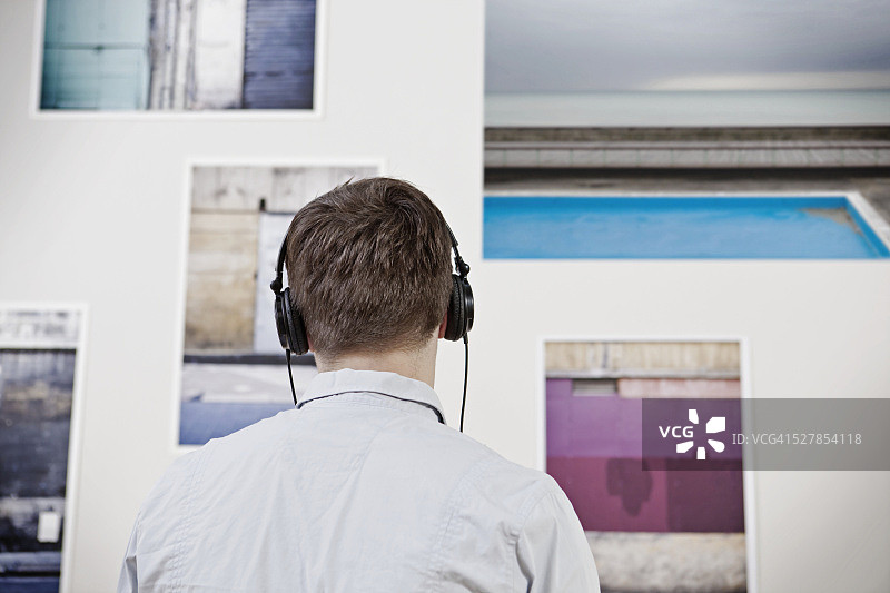 男人看着墙上的照片图片素材