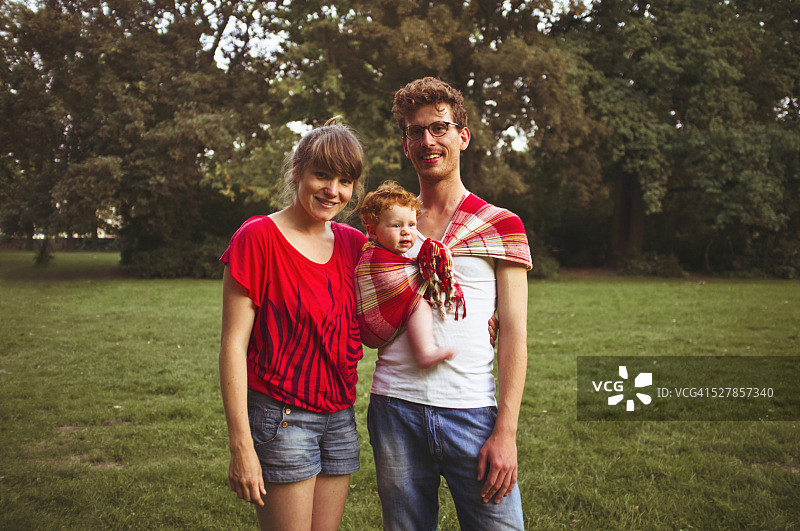 公园里抱着男婴（6-12个月）的家庭合影图片素材
