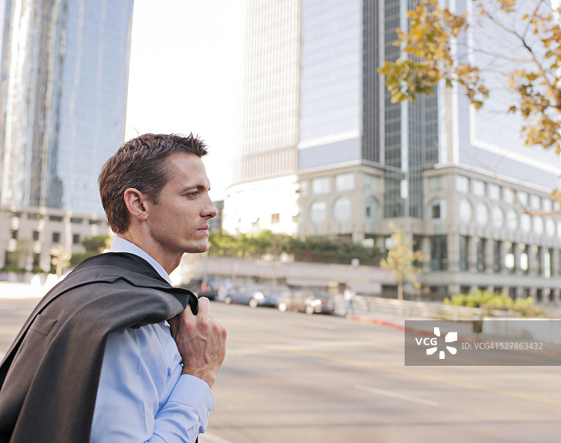 随意地把夹克搭在肩上的商人图片素材