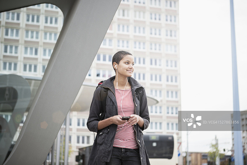 年轻女子在公交车站等车图片素材