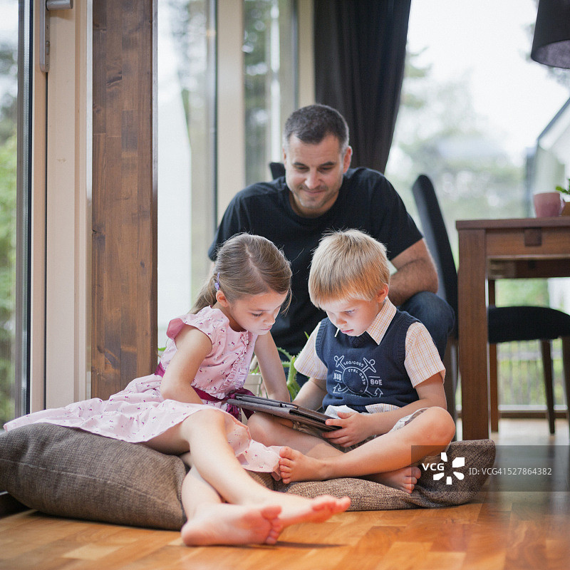 一家人围坐在平板电脑旁图片素材