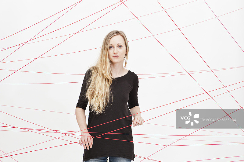 女人站在缠绕的绳子之间图片素材