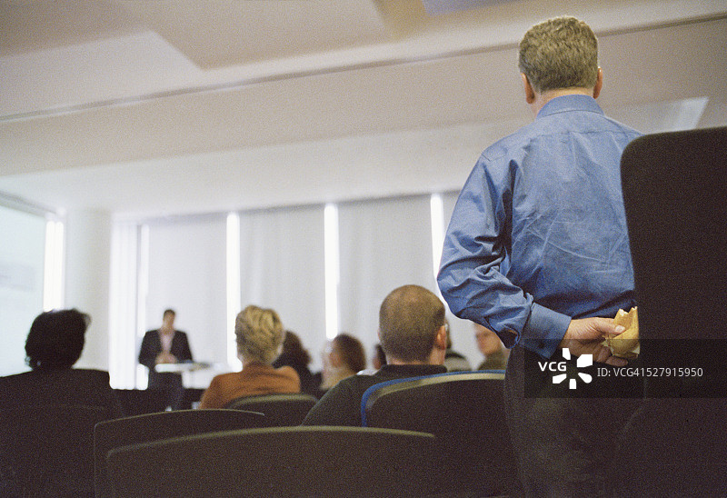 将三明治藏在身后的商人图片素材