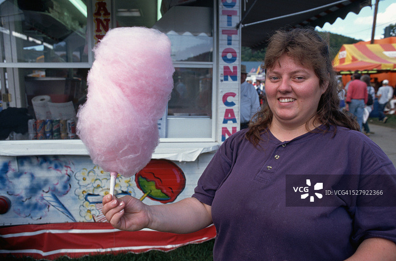 手持粉色棉花糖的女人图片素材