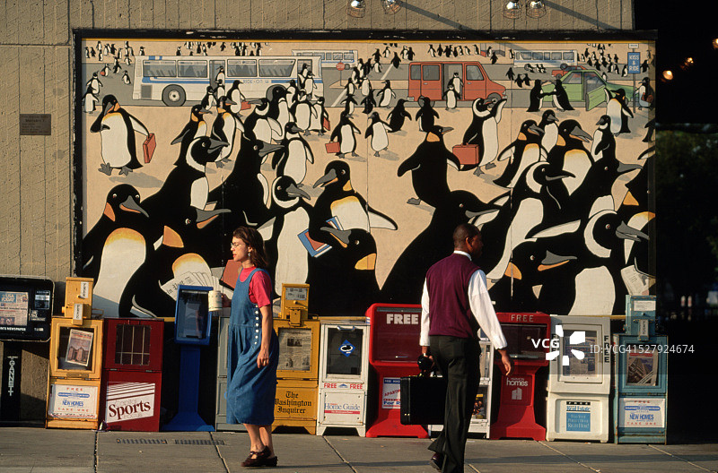 步行穿过企鹅壁画的通勤者图片素材
