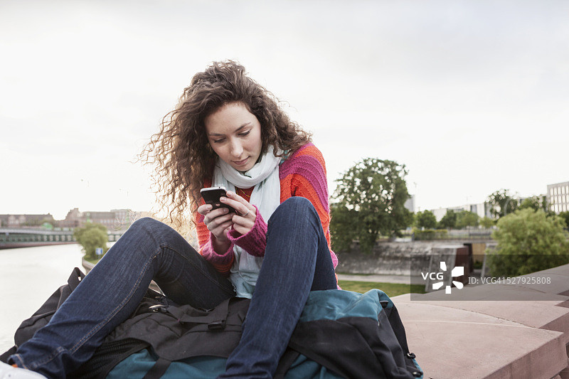 年轻女人用智能手机发短信图片素材