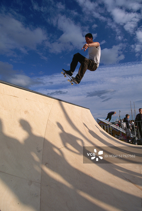 在奥斯陆木制坡道上练习的滑板运动员图片素材
