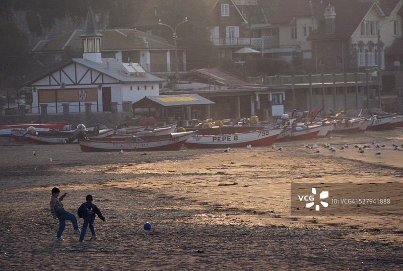男孩在帕普多海滩踢足球图片素材