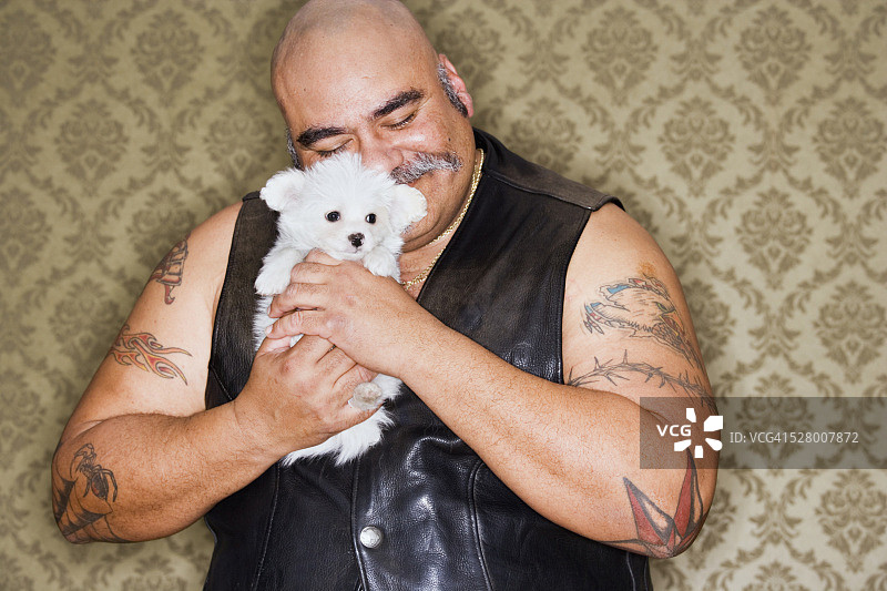 有纹身的男人抱着小狗图片素材