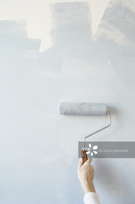 女人用滚筒刷油漆图片素材