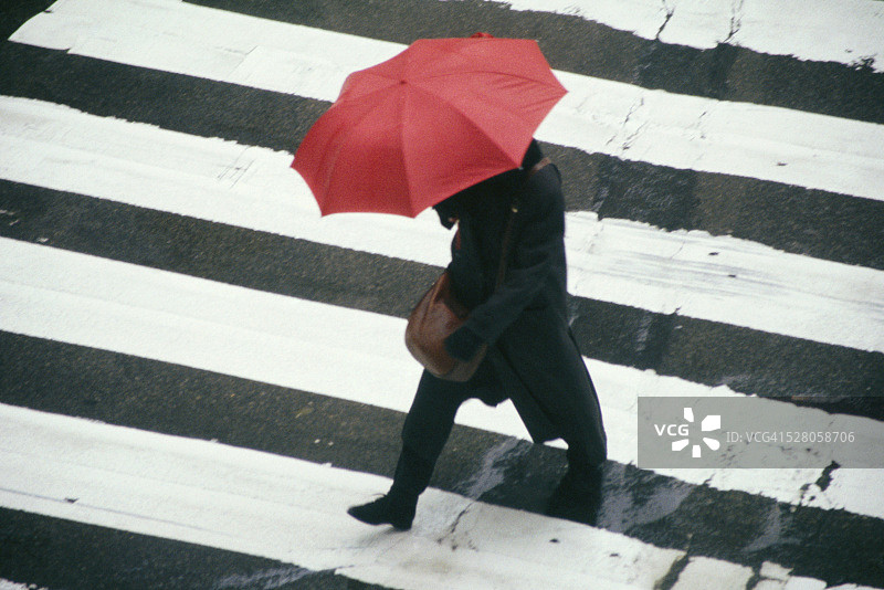 在人行横道上撑着红色雨伞图片素材