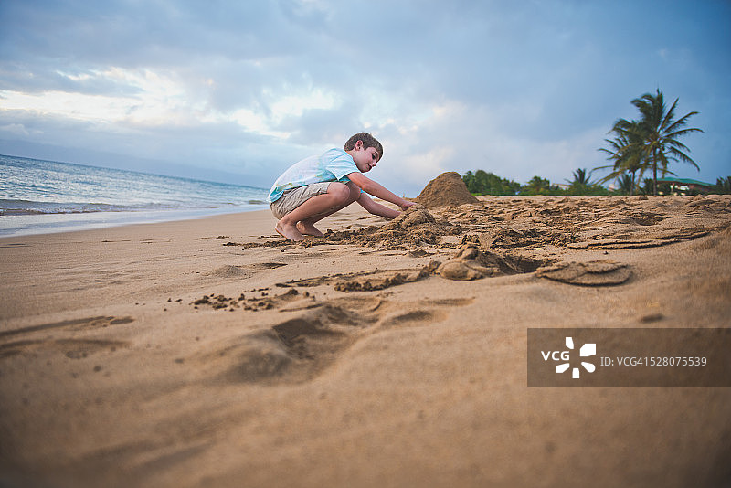 男孩在夏威夷的沙滩上玩耍图片素材