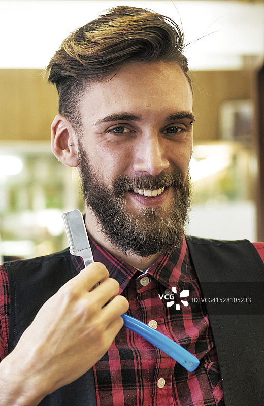 拿着剃须刀的年轻胡须潮人图片素材