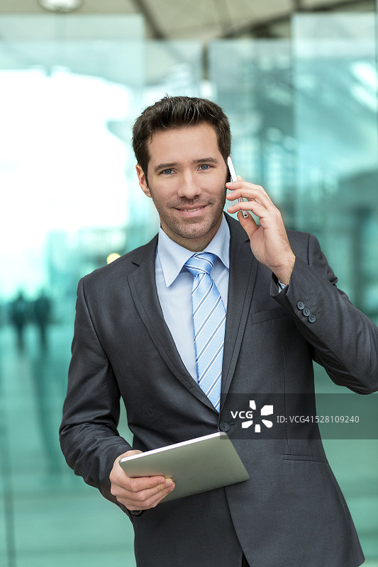 在法国巴黎使用平板电脑和智能手机的商务人士肖像图片素材