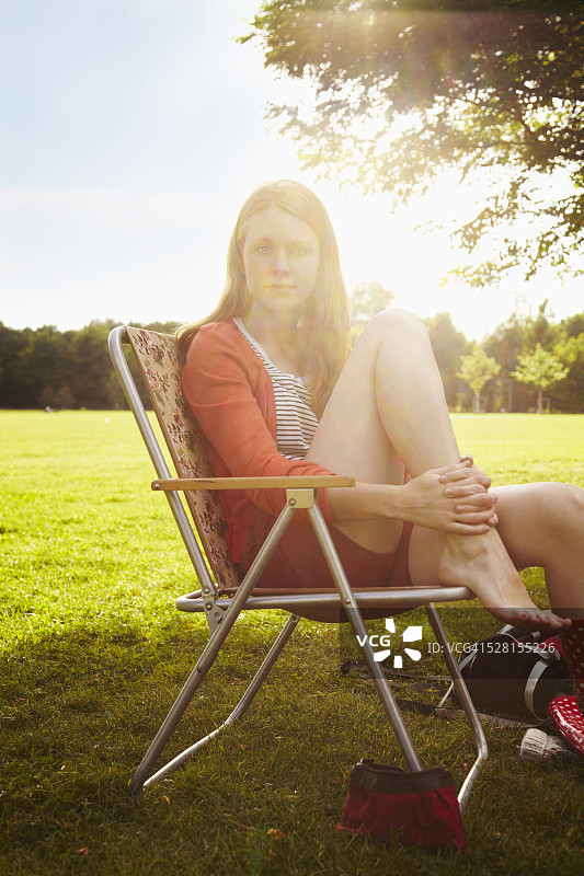 年轻女子坐在露营椅上休息图片素材