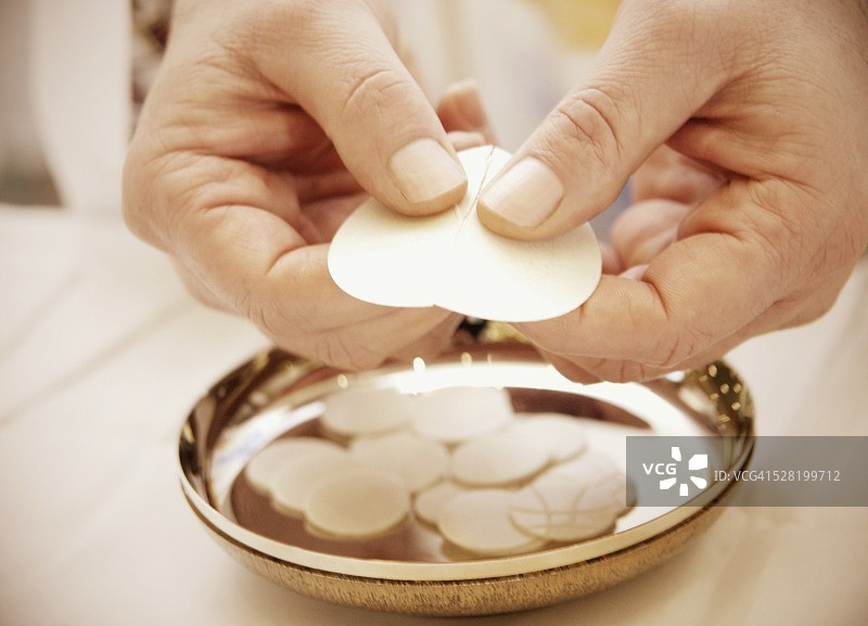 男人掰开圣餐薄饼图片素材