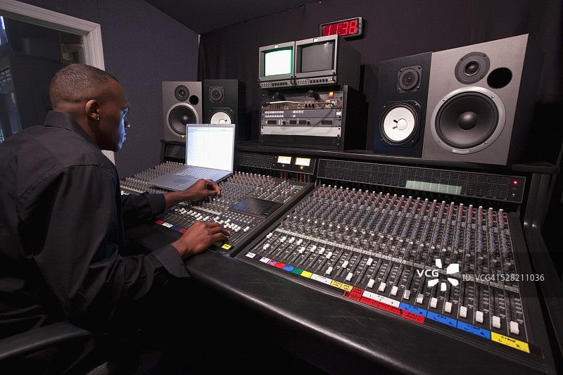 在录音棚使用调音台的男人图片素材