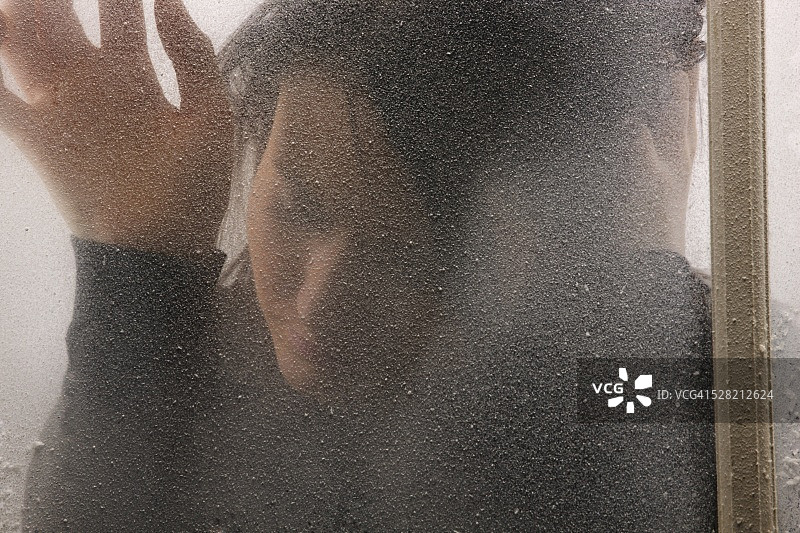 寒冷霜冻窗户后的女人图片素材