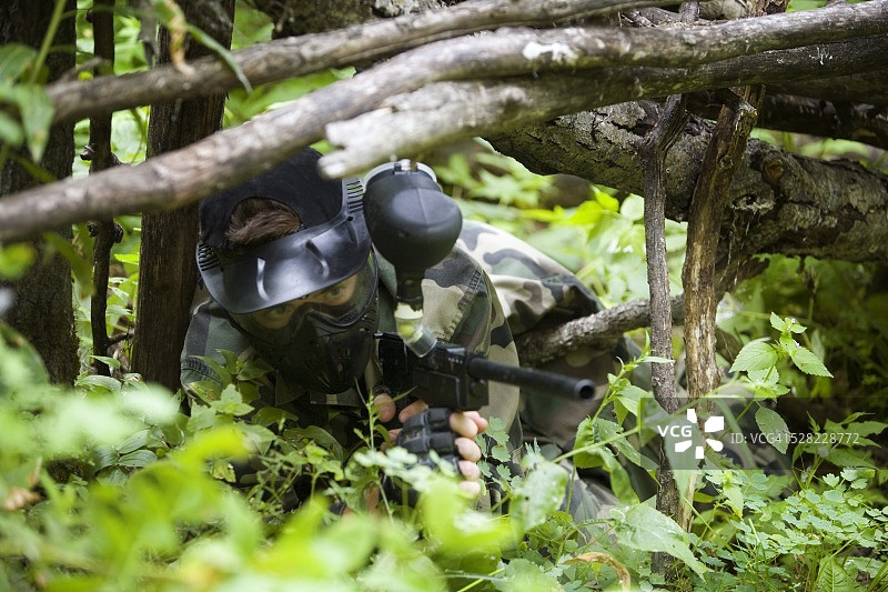 彩弹射击玩家在树枝下瞄准图片素材