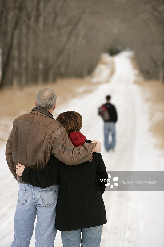 父母看着儿子去上学图片素材