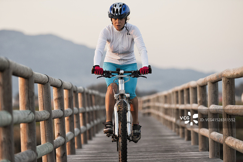 骑自行车的人在木板路上骑行：西班牙安达卢西亚图片素材