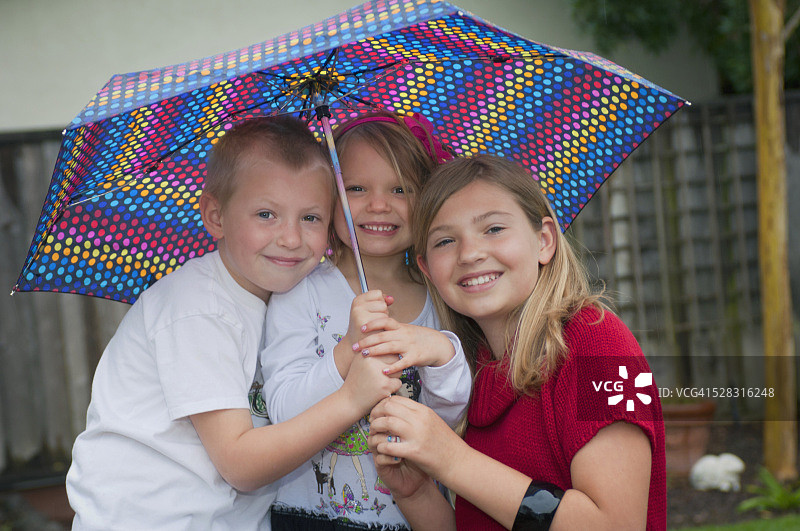 美国加州莫拉加三姐弟在伞下图片素材