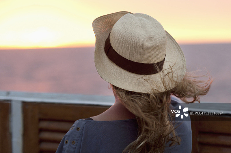 一位戴帽子的年轻女子在观赏日落；厄瓜多尔加拉帕戈斯群岛图片素材