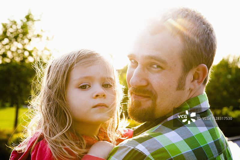父亲在阳光下抱着女儿；美国华盛顿州贝灵汉图片素材