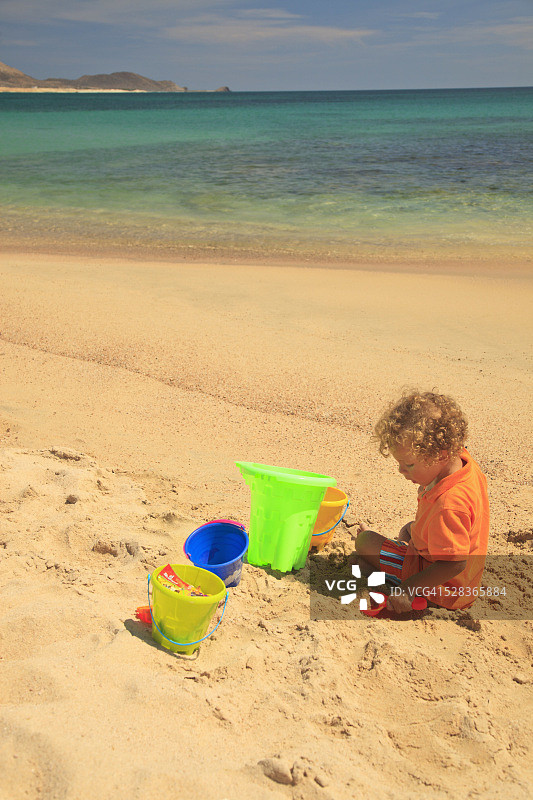 小男孩在墨西哥沙滩玩沙玩具图片素材