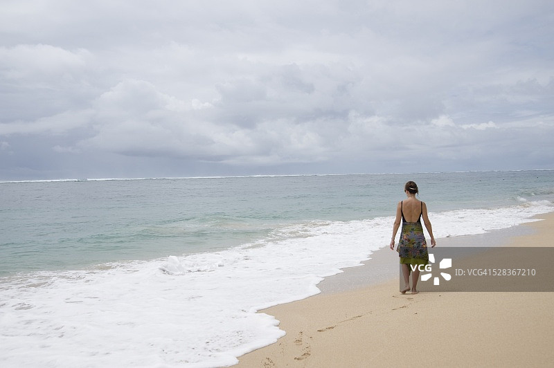 印度尼西亚巴厘岛努沙杜瓦海滩；在海滩上行走的女人图片素材