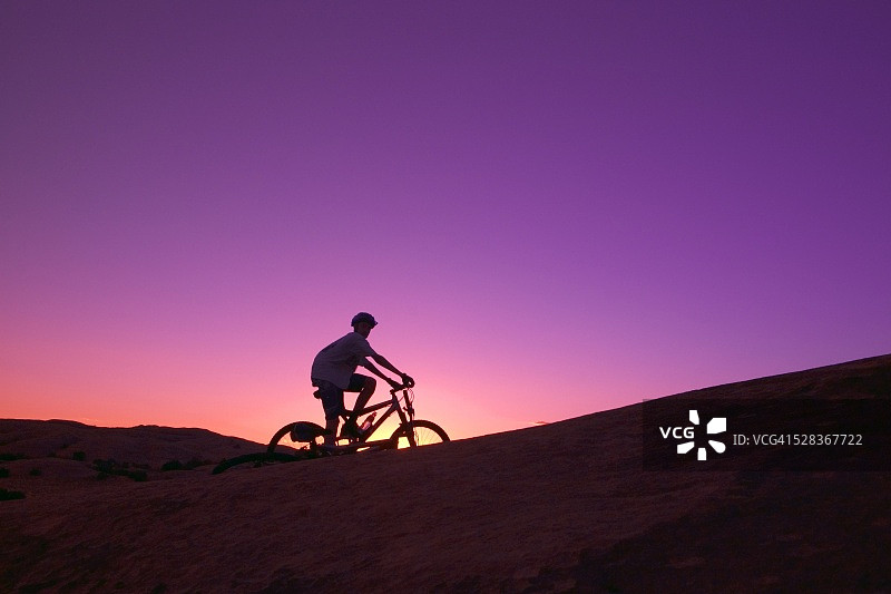 日落时骑自行车的人物图片素材