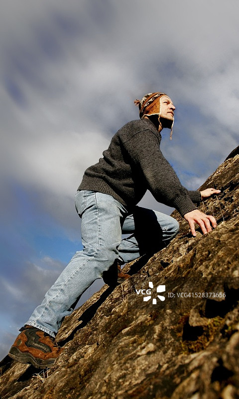 男人攀爬陡峭斜坡图片素材