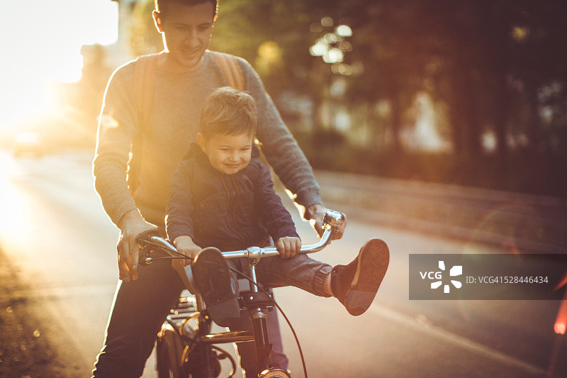 年轻的自行车手和他的父亲图片素材