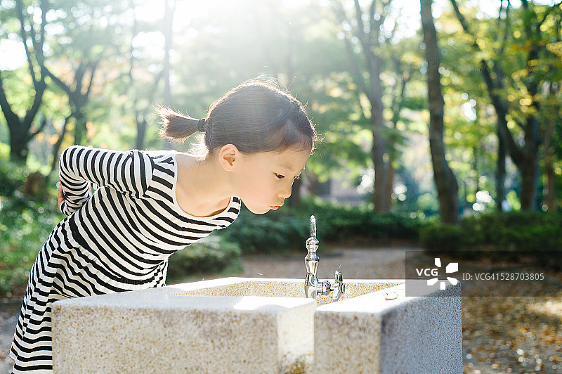 在饮水机喝水的女孩图片素材