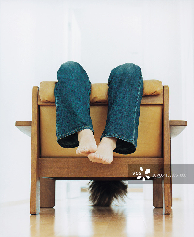 年轻男子倒坐在椅子上图片素材