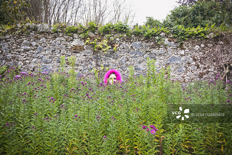 躲在花丛中的年轻女人图片素材